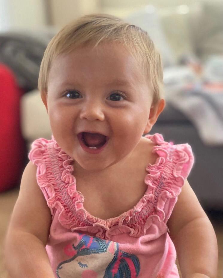 Aviva, smiling big in a pink shirt
